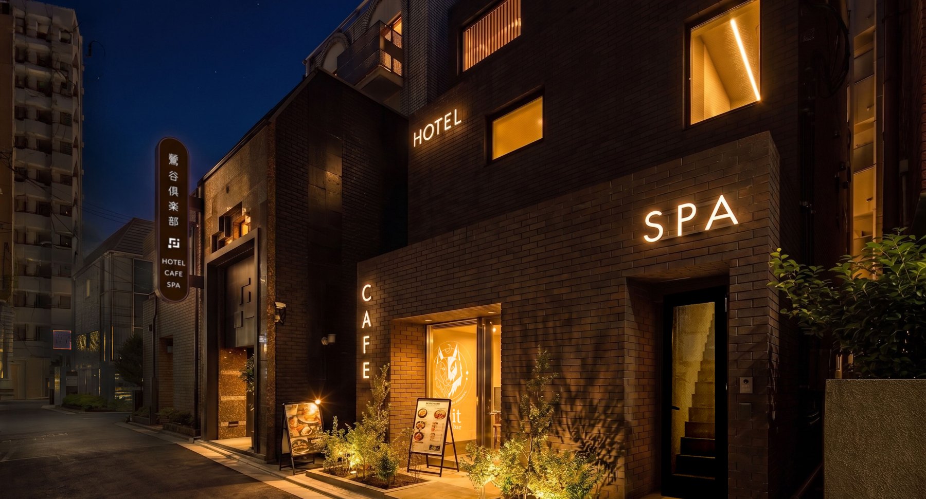 夜の鶯谷。事務所のある建物。CAFE とSPA の入口に灯りがともる