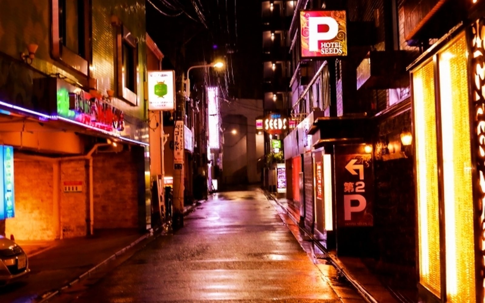 夜の路地。ネオンの看板と、通りに落ちる灯り
